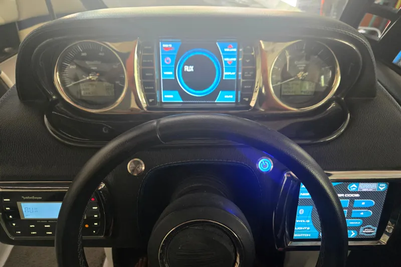 Slide: The Image of Dashboard of a 2013 Malibu Wakesetter 24 MXZ boat with digital displays and controls. - 19