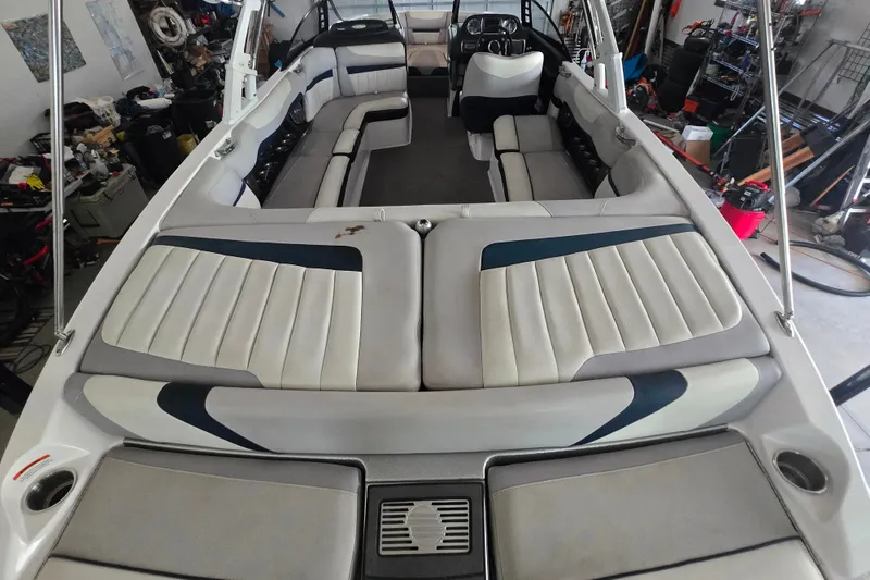 Slide: The Image of 2013 Malibu Wakesetter 24 MXZ interior with spacious seating and sleek design in a garage setting. - 22