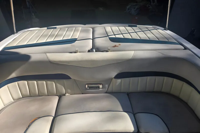 Slide: The Image of 2013 Malibu Wakesetter 24 MXZ boat interior with cushioned seating and sunlit upholstery. - 16