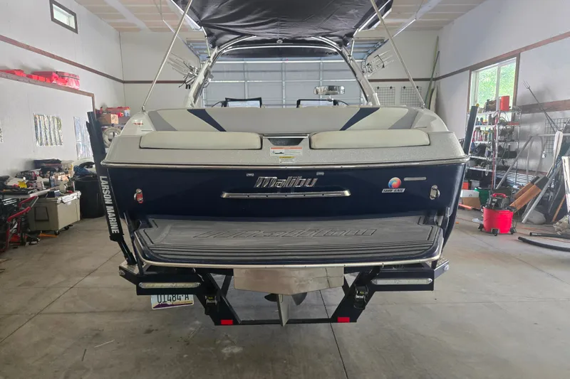 Slide: The Image of 2013 Malibu Wakesetter 24 MXZ boat in a garage, rear view. - 24