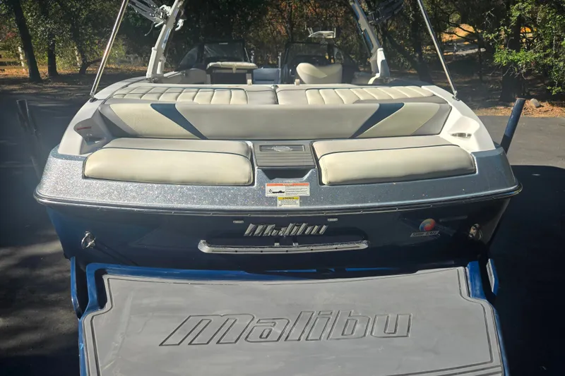 Slide: The Image of 2013 Malibu Wakesetter 24 MXZ boat with cushioned seating and sleek design. - 4