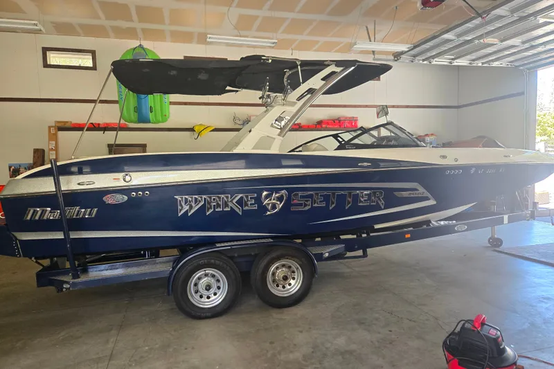 Slide: The Image of 2013 Malibu Wakesetter 24 MXZ boat on trailer in garage setting. - 23