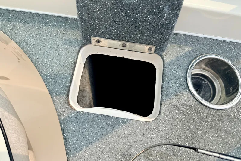 Slide: The Image of Open storage compartment on a 2012 Bryant 268 boat deck with cup holder. - 46