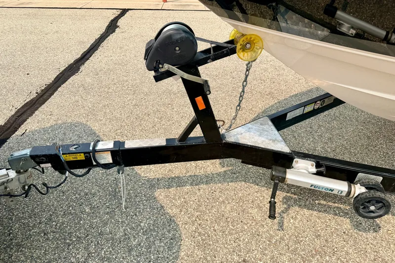 Slide: The Image of Trailer hitch of a 2012 Bryant 268 boat on pavement. - 108