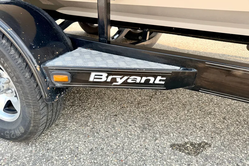 Slide: The Image of Close-up of a 2012 Bryant 268 trailer hitch with logo and tire detail. - 116
