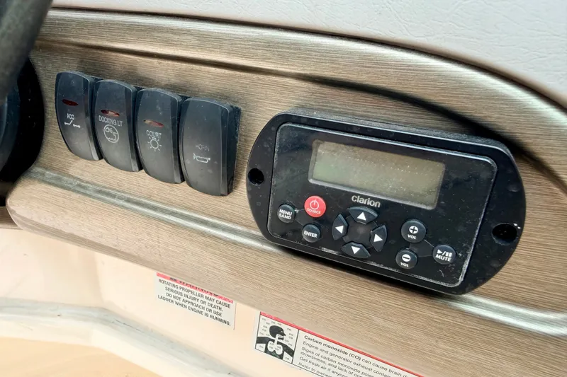 Slide: The Image of Control panel of a 2012 Bryant 268 boat with Clarion audio system and switches. - 55