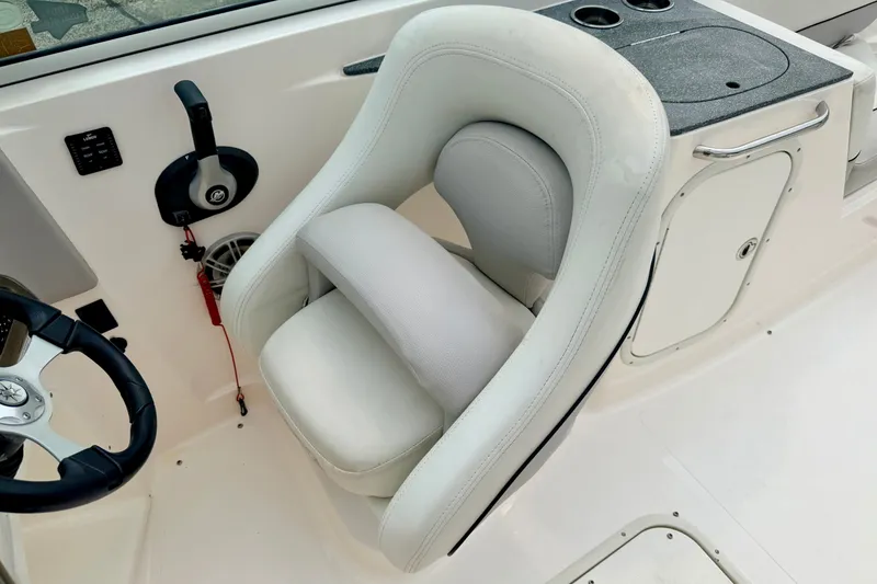 Slide: The Image of Captain's seat in a 2012 Bryant 268 boat, featuring a steering wheel and control panel. - 60