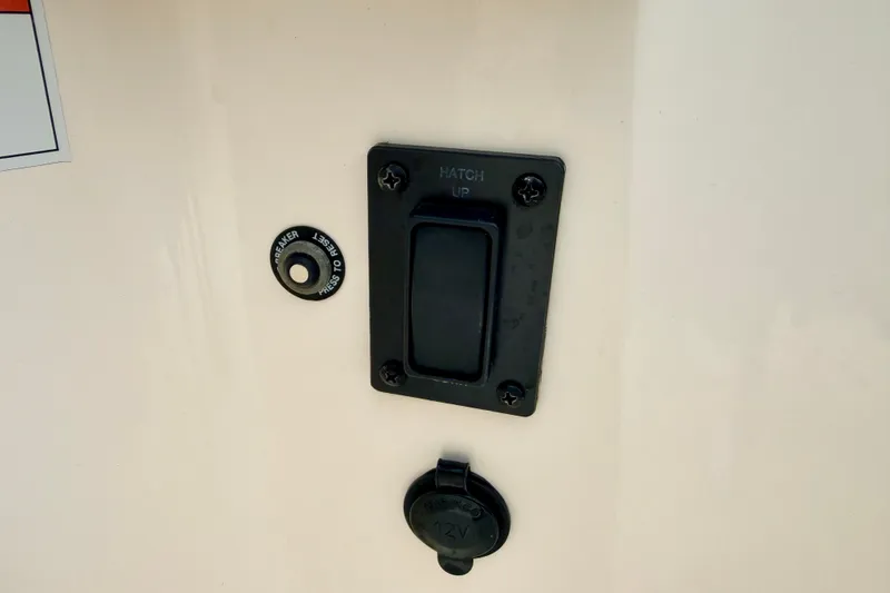 Slide: The Image of Switch panel on a 2012 Bryant 268 boat, featuring hatch control and 12V outlet. - 57