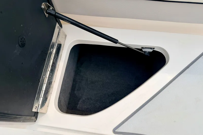 Slide: The Image of Open storage compartment in a 2012 Bryant 268 boat, featuring a hydraulic lift support. - 34