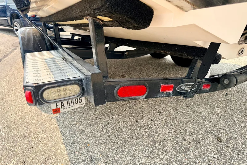 Slide: The Image of Trailer hitch of a 2012 Bryant 268 boat with license plate and LED lights. - 112
