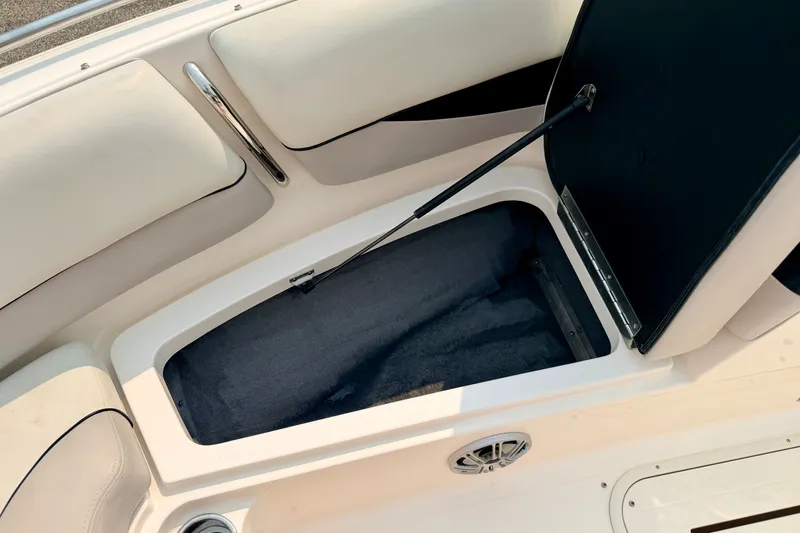 Slide: The Image of Open storage compartment in a 2012 Bryant 268 boat with cushioned seating. - 81