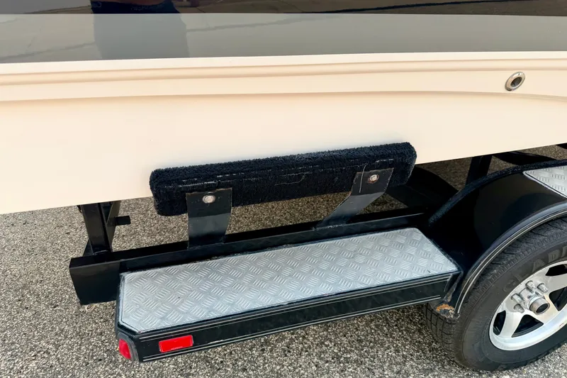 Slide: The Image of 2012 Bryant 268 boat trailer with textured step and black fender on asphalt. - 114