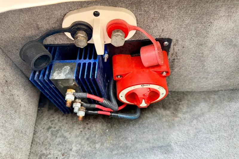 Slide: The Image of Electrical components in a 2012 Bryant 268 boat, featuring a red battery switch and blue heat sink. - 42