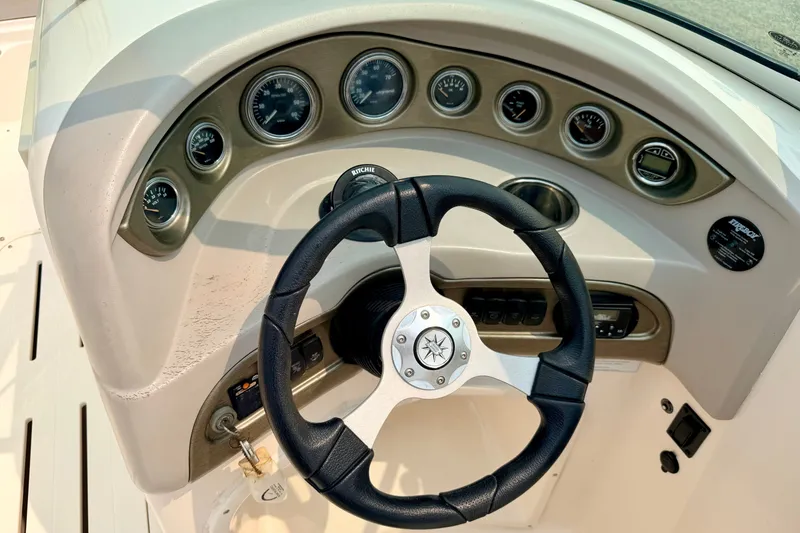 Slide: The Image of Steering wheel and dashboard of a 2012 Bryant 268 boat with gauges and controls. - 52
