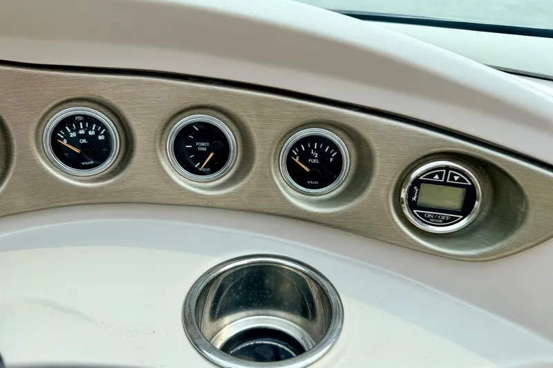 Slide: The Image of Dashboard gauges of a 2012 Bryant 268 boat, displaying oil, power trim, and fuel levels. - 54
