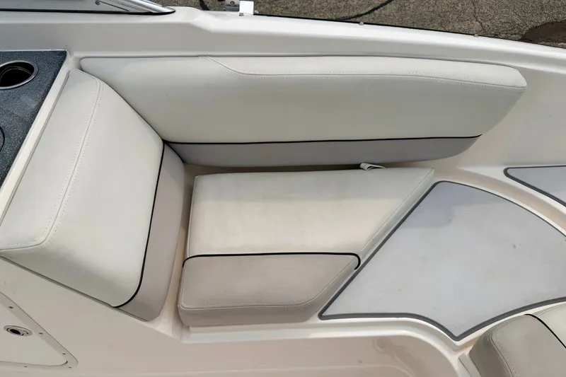 Slide: The Image of White seating area on a 2012 Bryant 268 boat, featuring cup holders and cushioned seats. - 33