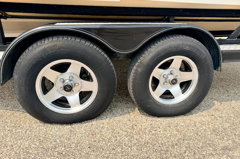 Slide: The Image of Trailer wheels on a 2012 Bryant 268 boat, featuring radial tires and alloy rims. - 110