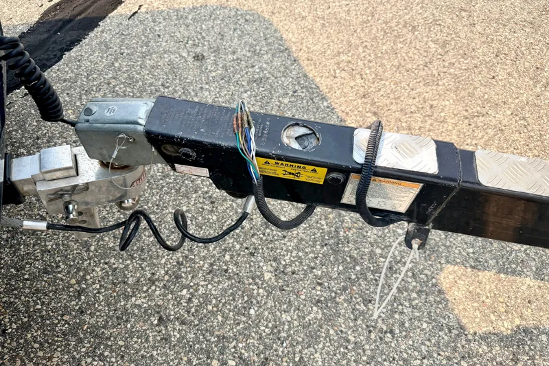 Slide: The Image of Trailer hitch of a 2012 Bryant 268 on asphalt, featuring wiring and safety warnings. - 105