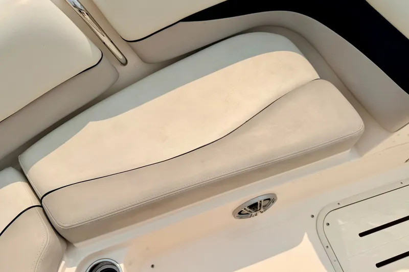 Slide: The Image of Cream-colored seating on a 2012 Bryant 268 boat, featuring sleek design and integrated speaker. - 80