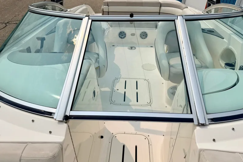 Slide: The Image of 2012 Bryant 268 boat interior with white seating and sleek windshield design. - 90