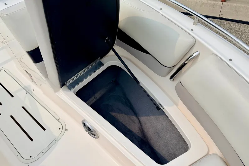 Slide: The Image of Open storage compartment on a 2012 Bryant 268 boat, featuring white cushioned seating. - 78