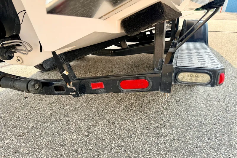 Slide: The Image of Trailer hitch and lights of a 2012 Bryant 268 boat on pavement. - 113