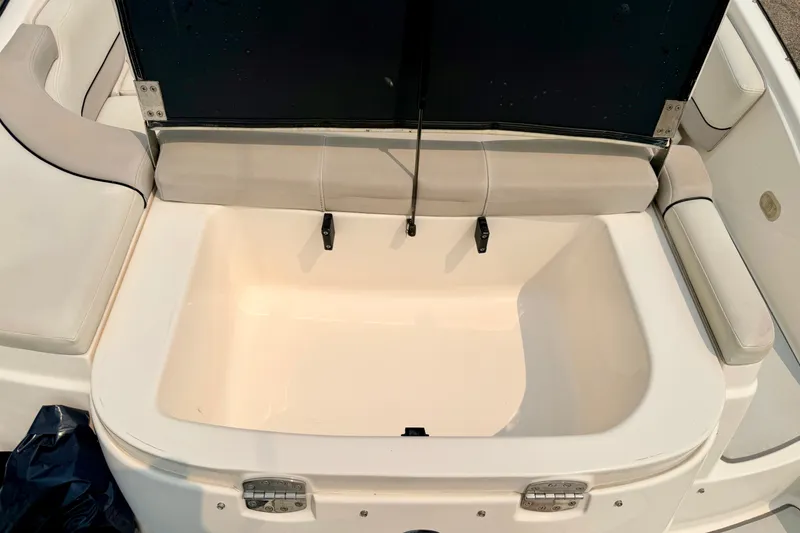 Slide: The Image of Open storage compartment on a 2012 Bryant 268 boat with cushioned seating. - 96