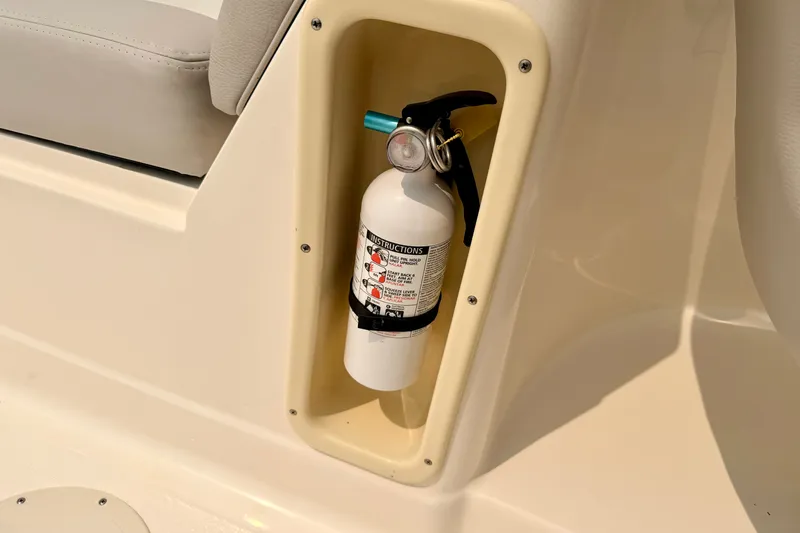 Slide: The Image of Fire extinguisher mounted on a 2012 Bryant 268 boat, near a cushioned seat. - 49