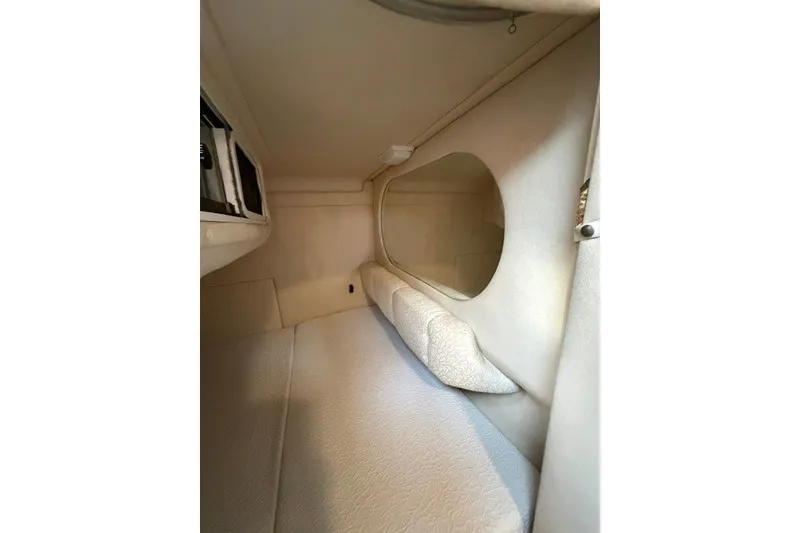 Slide: The Image of 2001 Sea Ray Sundancer 260 cabin interior with cozy sleeping area and round window. - 8