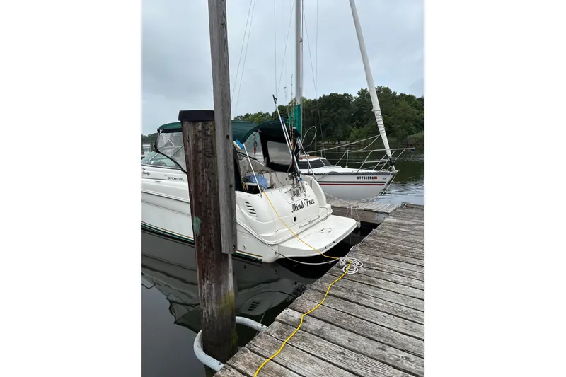 Slide: The Image of 2001 Sea Ray Sundancer 260 docked at a marina with sailboat nearby. - 11