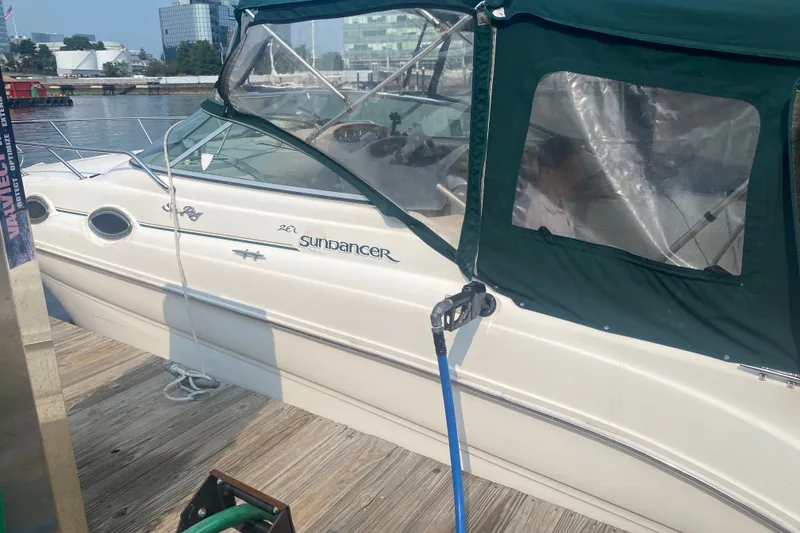 Slide: The Image of 2001 Sea Ray Sundancer 260 docked with green canopy in marina setting. - 21