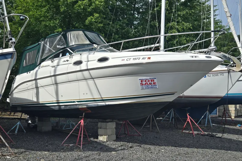 Slide: The Image of 2001 Sea Ray Sundancer 260 boat for sale, elevated on stands, with green canopy. - 12