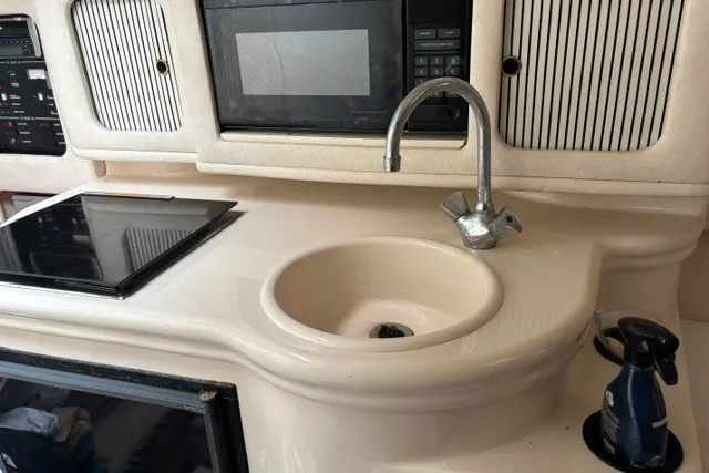 Slide: The Image of 2001 Sea Ray Sundancer 260 galley with sink, stove, and microwave. - 7