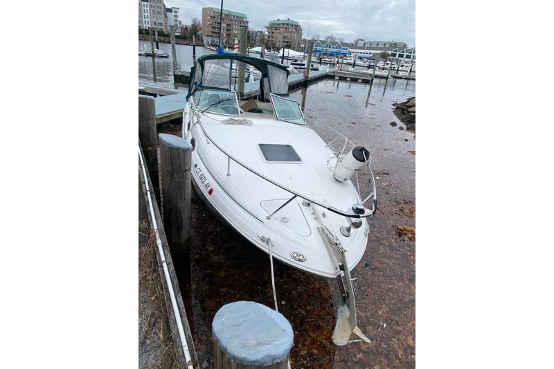 Slide: The Image of 2001 Sea Ray Sundancer 260 docked at a marina, surrounded by calm waters and buildings. - 18