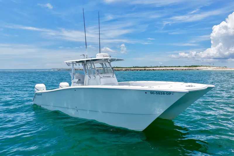 Slide: The Image of 2018 Freeman 34VH boat on clear blue water near a sandy shoreline. - 16
