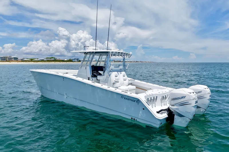 Slide: The Image of 2018 Freeman 34VH boat on open water, featuring twin Mercury engines under a clear sky. - 5