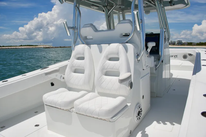 Slide: The Image of 2018 Freeman 34VH boat with white seating, stainless steel accents, and ocean backdrop. - 57