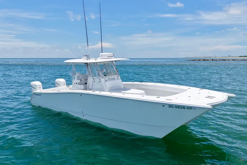 Slide: The Image of 2018 Freeman 34VH boat on clear blue water, featuring dual engines and sleek design. - 20
