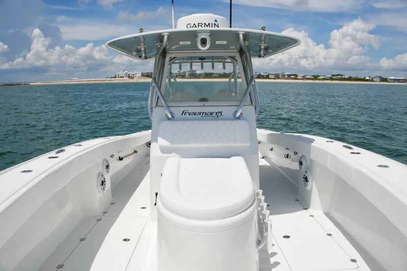 Slide: The Image of 2018 Freeman 34VH boat on water, featuring Garmin equipment, clear skies, and coastal background. - 40