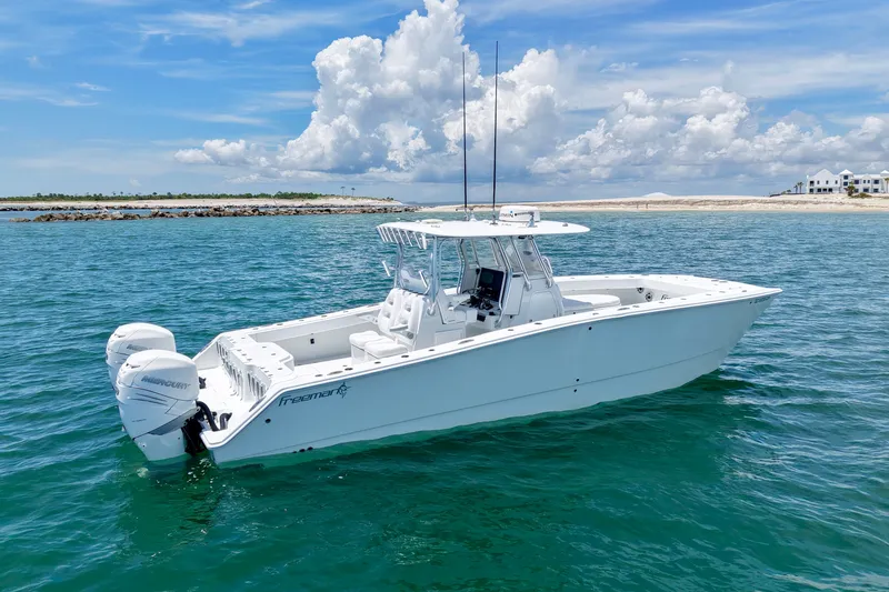 Slide: The Image of 2018 Freeman 34VH boat on clear blue water with scenic coastal background. - 12