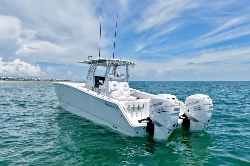 Slide: The Image of 2018 Freeman 34VH boat with twin Mercury engines on open sea under blue sky. - 34
