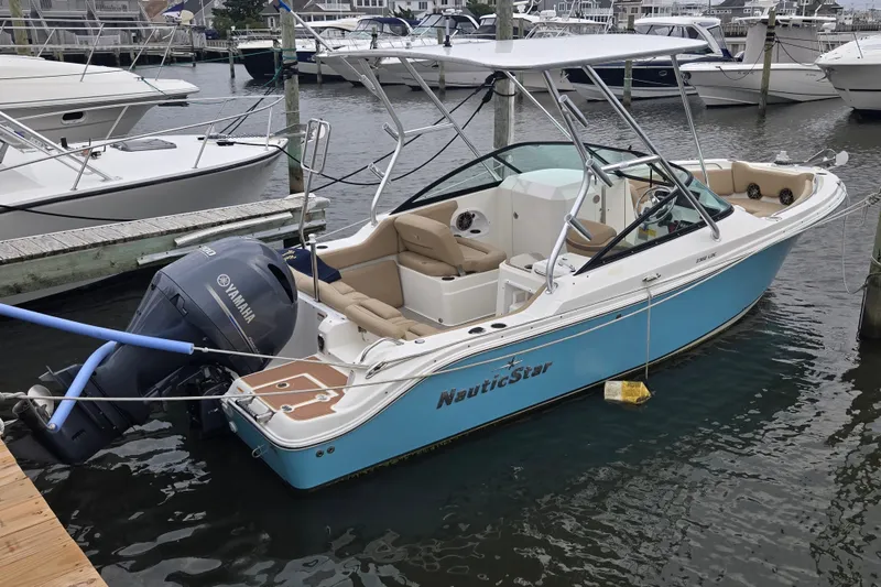 The Image of 2020 NauticStar 2302 Legacy Dual Console boat docked with Yamaha outboard motor. - 0