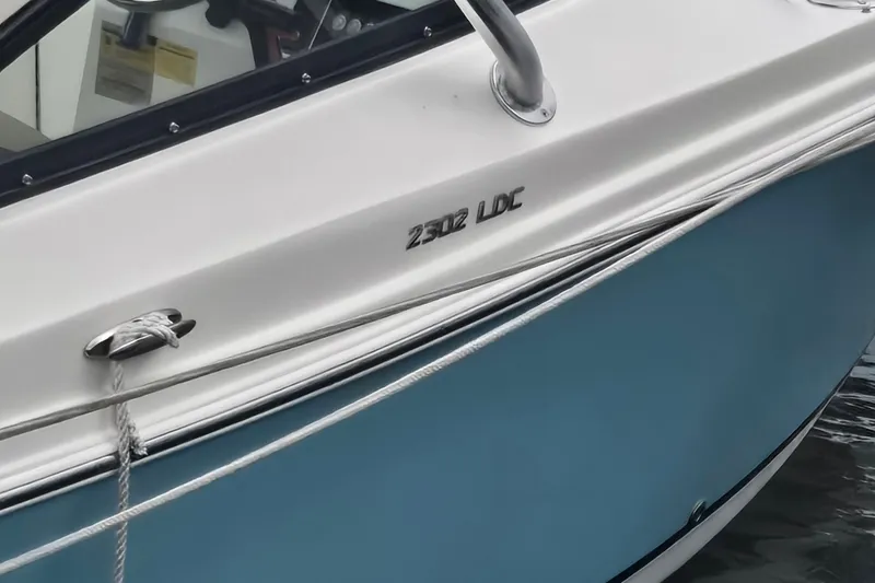 Slide: The Image of 2020 NauticStar 2302 Legacy Dual Console boat, blue hull, docked with rope. - 7
