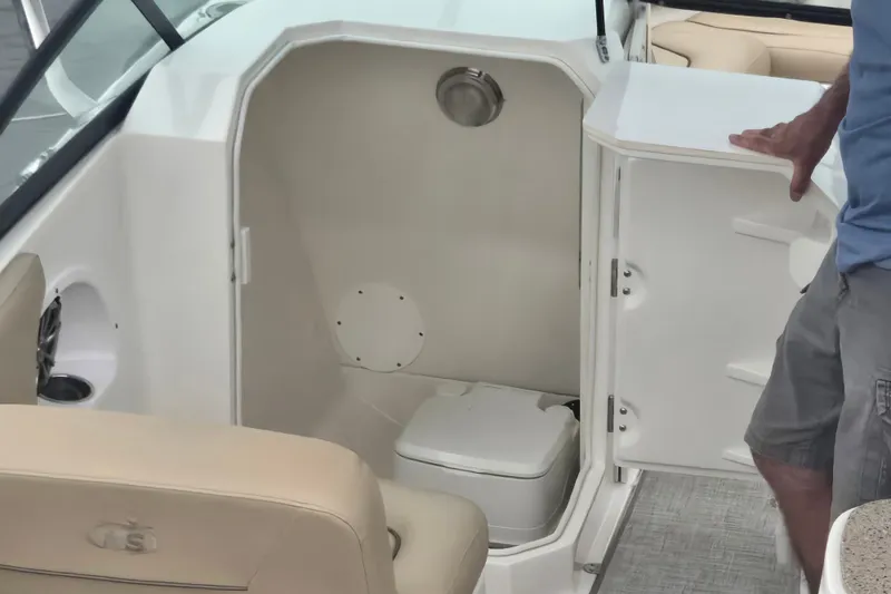 Slide: The Image of 2020 NauticStar 2302 Legacy Dual Console boat interior with compact restroom. - 4