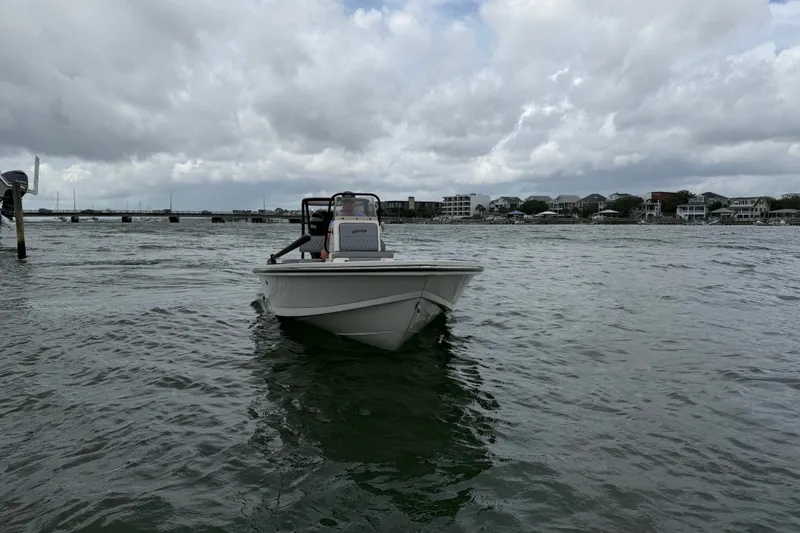 Slide: The Image of 2020 Hewes Redfisher 18 boat on water under cloudy sky near shoreline. - 4