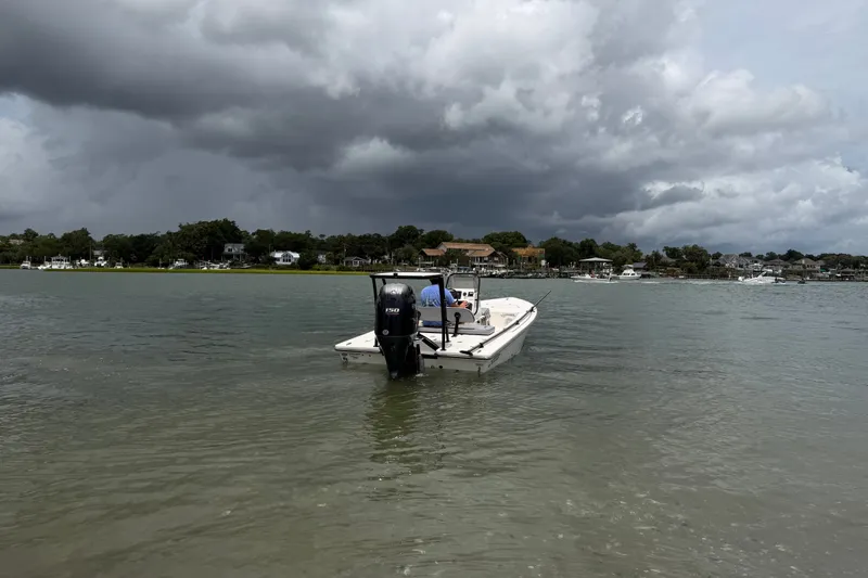 Slide: The Image of 2020 Hewes Redfisher 18 boat on calm water under cloudy skies. - 8