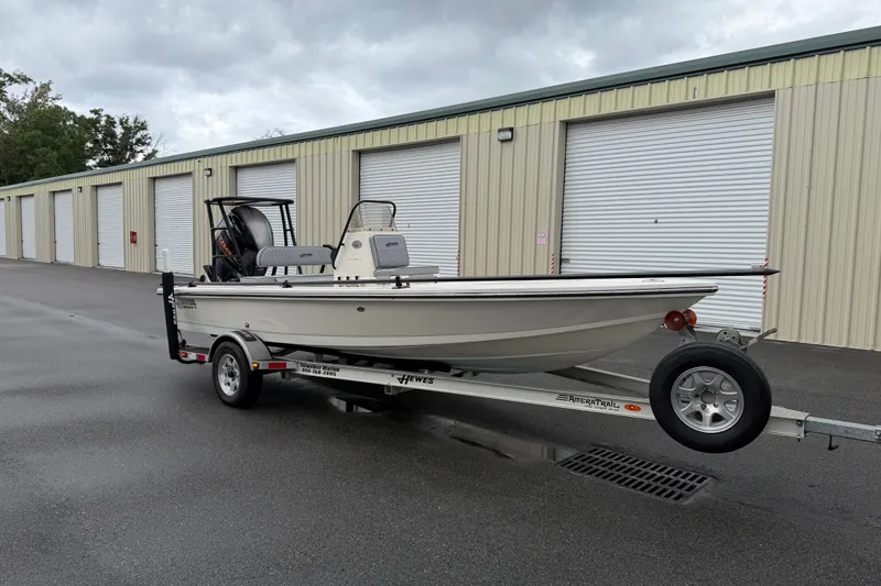 Slide: The Image of 2020 Hewes Redfisher 18 boat on trailer, parked near storage units. - 12