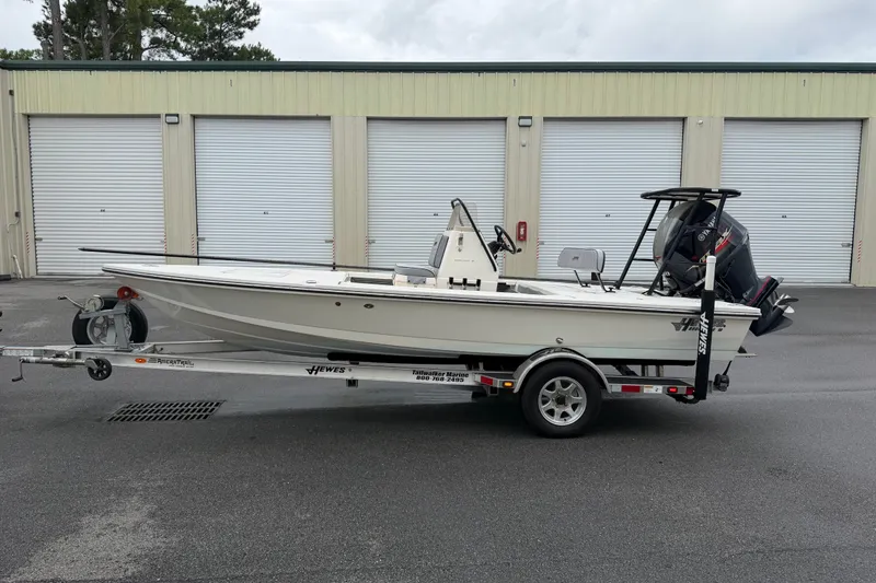 Slide: The Image of 2020 Hewes Redfisher 18 boat on trailer, parked in front of storage units. - 17