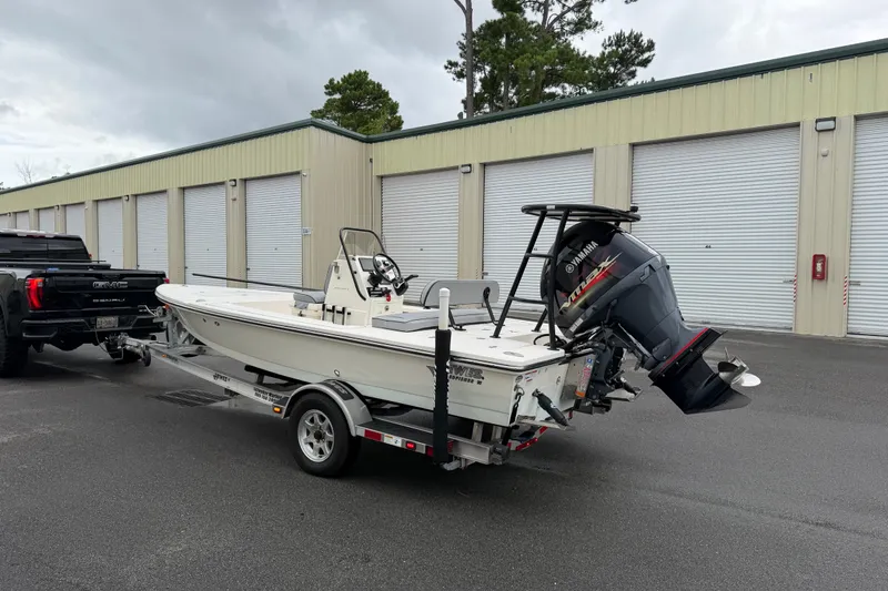 Slide: The Image of 2020 Hewes Redfisher 18 boat on trailer, parked near storage units. - 16