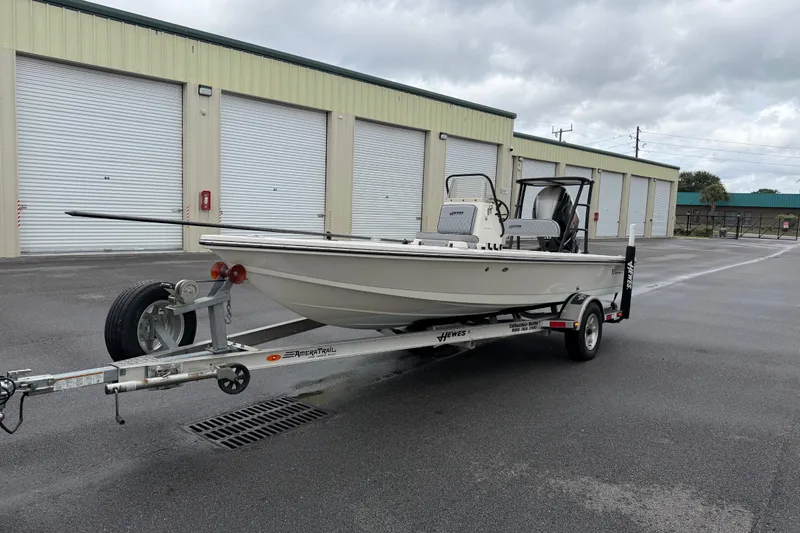 Slide: The Image of 2020 Hewes Redfisher 18 boat on trailer, parked outside storage units. - 18